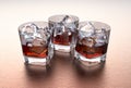 Glasses of whiskey with ice cubes on a metal table Royalty Free Stock Photo