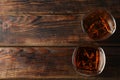 Glasses of whiskey with ice cubes on wooden background Royalty Free Stock Photo