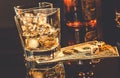 Glasses of whiskey near bottle on dollars money and gaming dice on a black table Royalty Free Stock Photo