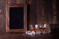 Glasses of whiskey on wood background