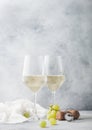 Glasses of white homemade summer refreshing wine with corks and grapes on light background Royalty Free Stock Photo