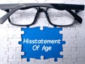 Glasses and white puzzle with the word Misstatement Of Age