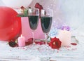 Glasses of wine, gifts, a bouquet of fresh roses, burning candles and balloons, the concept of a holiday, congratulations, happy b Royalty Free Stock Photo