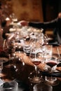 Glasses of wine on a long table in a restaurant. Table setting for a celebration and tasting. Natural light. Soft focus Royalty Free Stock Photo