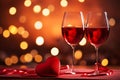 Glasses of wine and red heart shape on evening golden bokeh background. Saint Valentines day concept