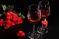 Glasses of wine, roses and heart shaped candles for romantic dinner on table Royalty Free Stock Photo