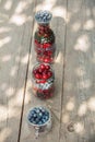 Glassware with different fresh berries on an old wooden bench. Fresh garden berries, blueberry,currant, cherry. top view Royalty Free Stock Photo
