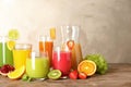 Glassware with different juices and fresh fruits on table