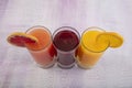 Glassware with refreshing citrus fruits cocktail on white wooden background. Antioxidant juices of Pomegranate Juice, Orange Juice Royalty Free Stock Photo