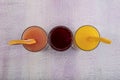 Glassware with refreshing citrus fruits cocktail on white wooden background. Antioxidant juices of Pomegranate Juice, Orange Juice