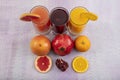 Glassware with refreshing citrus fruits cocktail on white wooden background. Antioxidant juices of Pomegranate Juice, Orange Juice