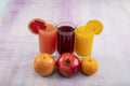 Glassware with refreshing citrus fruits cocktail on white wooden background. Antioxidant juices of Pomegranate Juice, Orange Juice