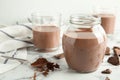 Glassware with tasty chocolate milk on marble table.