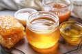 Glassware with tasty honey on wooden table, closeup