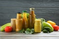 Glassware with tasty sauces and vegetables on wooden table