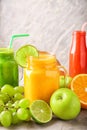 Glassware of tasty smoothies with fruits on grey table