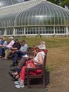 Glaswegians basking in the sun on benches outside in the Glasgow Botanic Gardens Grounds in Central Glasgow.