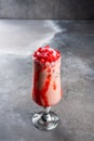 Glaxy smoothie with pomegranate served in dish isolated on dark background side view