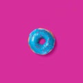 Glazed blue donut on a pink background