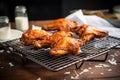 glazed buffalo wings on cooling rack with parchment paper