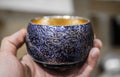 Purple ceramic cup in a hand