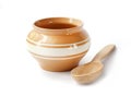 Glazed ceramic pot for cooking with wooden spoon on a white back Royalty Free Stock Photo