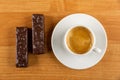 Chocolate wafers, cup with black coffee in saucer on wooden table. Top view Royalty Free Stock Photo