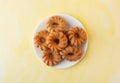 Glazed crullers on a plate atop a yellow background Royalty Free Stock Photo
