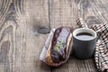 Glazed eclairs with a cup of coffee on wooden table Royalty Free Stock Photo