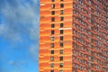 glazed facade of a high-rise building against a blue sky