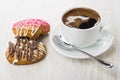 Glazed gingerbread, coffee in cup, spoon on saucer on table