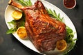 Glazed lamb leg roast on a dish garnished with lemon slices and fresh rosemary. Festive meal for family dinner holiday celebration Royalty Free Stock Photo