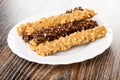 Glazed wafer rolls in chocolate with peanut in white plate on table