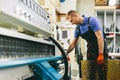 Glazier worker operates glass cutting machine in workshop