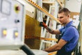 Glazier worker operates glass cutting machine in workshop