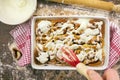 Glazing cinnamon rolls with icing from whisk Royalty Free Stock Photo