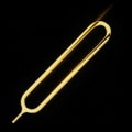 Gleaming Gold SIM Card Ejector Tool on a Dark Reflective Surface with Dramatic Lighting Royalty Free Stock Photo