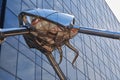 Head of Martian tripod in front of glass office block. Woking, England.