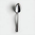 A shiny silver spoon resting on a plain white surface top isolated on white background Royalty Free Stock Photo