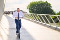 Gleeful businessman enjoying his ride on an electric scooter