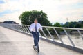 Gleeful businessman enjoying his ride on an electric scooter