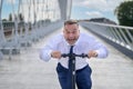 Gleeful laughing man speeding along on an electric scooter