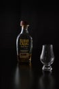 A glencairn glass accompanied by a small bottle of bourbon