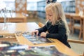 Little girl working on puzzle in public library
