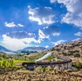 Glenfinnan Railway Viaduct in Scotland with the Jacobite steam train against sunset Royalty Free Stock Photo