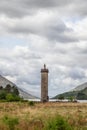 The Glenfinnan Monument stands tall in the highlands, a rugged testimony to the past, framed by a dramatic sky