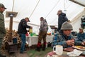 Group of hunters eat a breakfast meal inside of a tent before heading out to hunt.