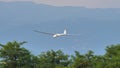 Glider in flight at very low altitude just above the treetops