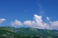 The glider pilot soars over mountains against the blue sky Royalty Free Stock Photo