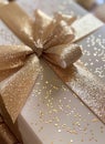 Elegant Sparkly Gold Ribbon Gift Box Wrapped for a Special Occasion on a Neutral Background